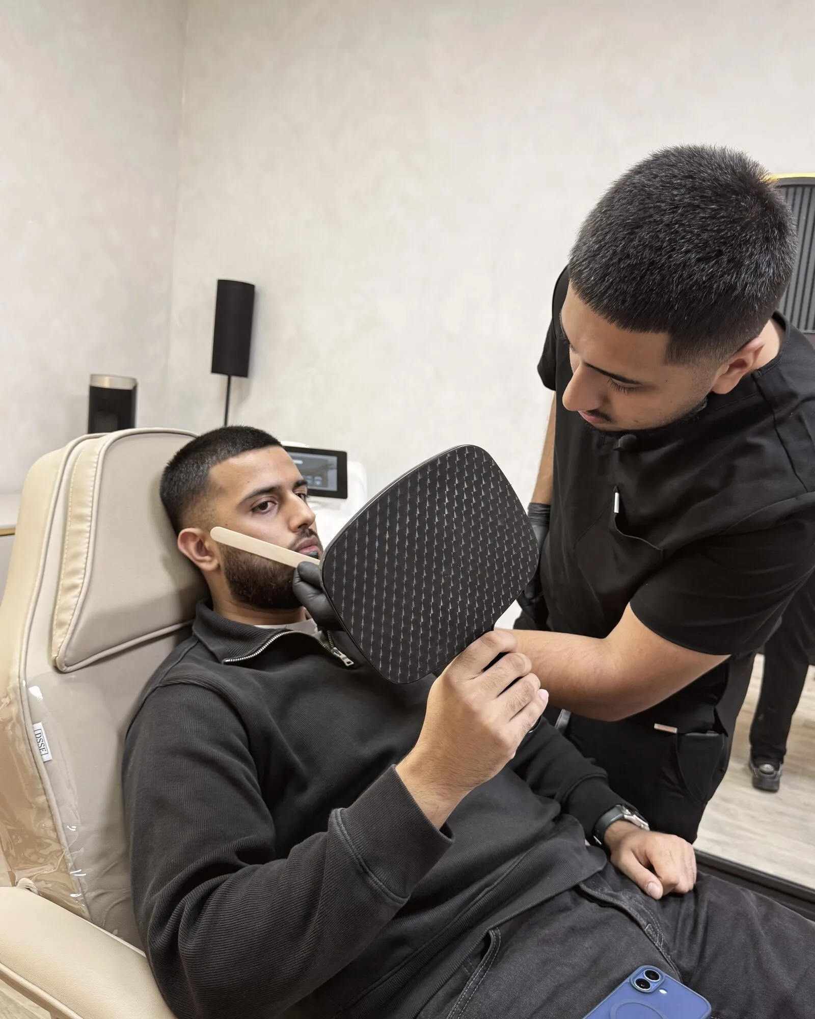 A client checking his marked beard line in a mirror before laser